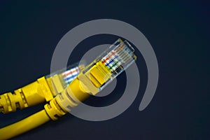 Yellow RJ-45 or ethernet internet cable on black background