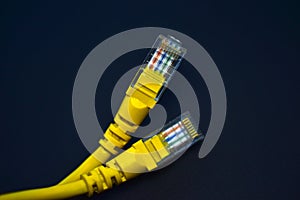 Yellow RJ-45 or ethernet internet cable on black background