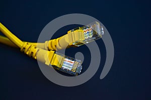 Yellow RJ-45 or ethernet internet cable on black background