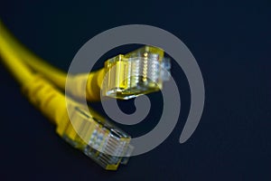 Yellow RJ-45 or ethernet internet cable on black background