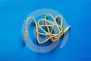 Yellow RJ-45 or ethernet internet cable on blue background