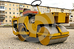 Yellow road roller front and side view, steering wheel and home-made sitting