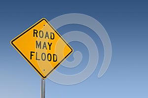 Road May Flood Sign Against A Blue Sky