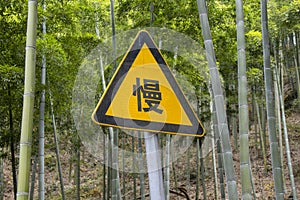 Yellow road sign with slow word in Chinese