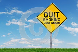 Yellow road sign with text of quit smoking