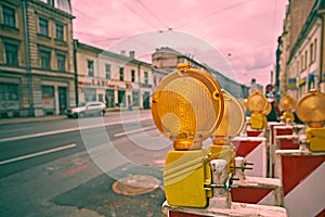Yellow road work flashers close up.