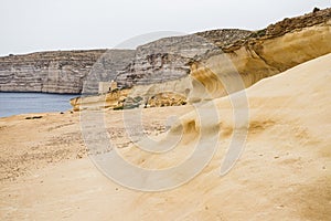 Yellow rock leads down to Xwejni Bay