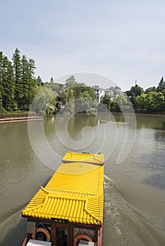 yellow roof of gaily-painted pleasure-boat