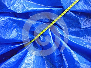 Yellow rope on blue tarpaulin