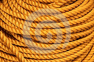 Yellow rope pile closeup photo. Ship or rock climbing tackle. Natural material woven cordage. Simple rope bulk concept