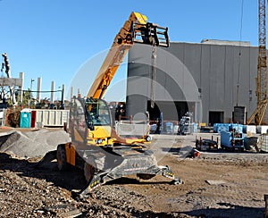 Yellow rotating telehandler at work in a construction site photo