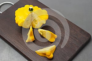 Yellow round zucchini and zucchini slices on a cutting board