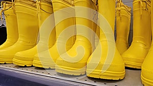 Yellow rubber boots on the shelf of a hardware store.