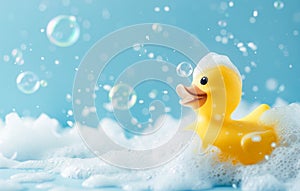 Yellow rubber duck in a soap foam on the light blue background with flying soap bubbles. Copy space