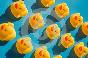 Yellow rubber ducks on a blue background with hard shadows