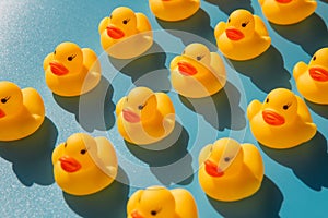 Yellow rubber ducks on a blue background with hard shadows