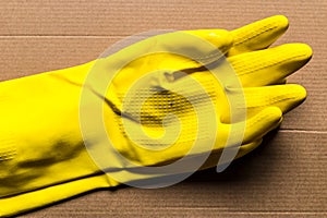 Yellow rubber gloves on cardboard box, delivery and safety during quarantine - Image