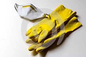 Yellow rubber gloves and protective face mask on white background, pollution, dust or virus protection - Image