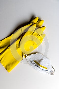Yellow rubber gloves and protective white mask on white background - Image