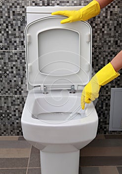 Yellow rubber gloves and toilet bowl