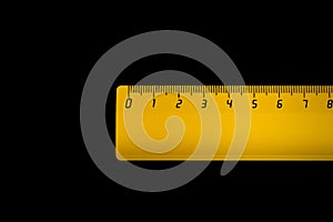 Yellow ruler on a black background 8 centimeters