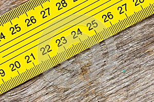 Yellow ruler on a wooden background