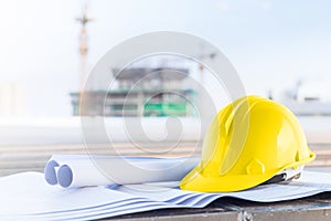 The yellow safety helmet and the blueprint at construction site