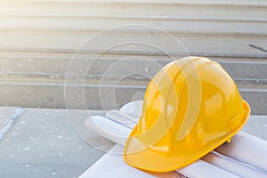 The yellow safety helmet and the blueprint at construction site