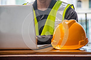 The yellow safety helmet and Business man in Construction industry is working in on computer