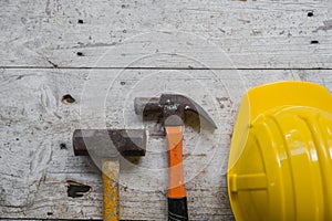 yellow safety helmet and rolled up architectural blueprints on a wooden desk