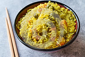 Yellow Saffron Basmati Rice with Turmeric and Vegetables Pilav or Pilaf in Bowl with Chopsticks.