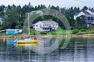 A yellow sail boat on a lake