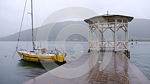 Yellow sailboat pitches at anchor on the quay