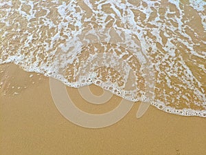 Yellow sand beach with white sea waves
