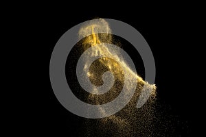 Yellow sand explosion isolated on black background