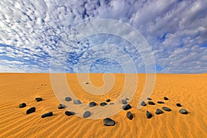 Yellow sand. Summer dry landscape in Africa. Black pebble stone.