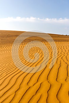 Yellow sandy wavy dunes in desert at daytime