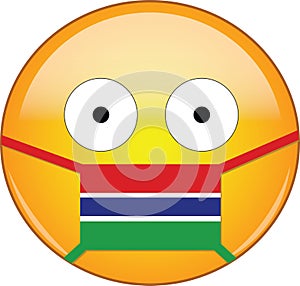 Yellow scared emoji in Gambian medical mask protecting from SARS, coronavirus, bird flu and other viruses, germs and bacteria and