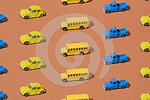 Yellow school bus, blue pickup truck and bug on a brown background. Pattern