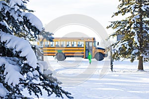 Yellow school bus brought a boy home in winter