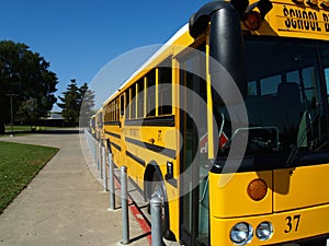 Yellow school bus parked along sidewalk curb