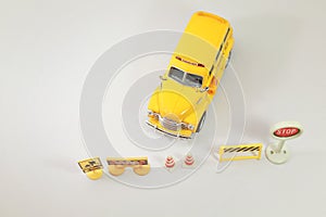 Yellow school bus  toy model  with traffic signs the road crossing.