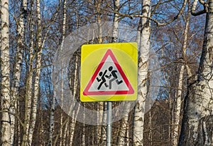 Yellow school road sign on a background of trees, Russia. carefully children
