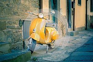 Yellow scooter in tuscan Cortona town