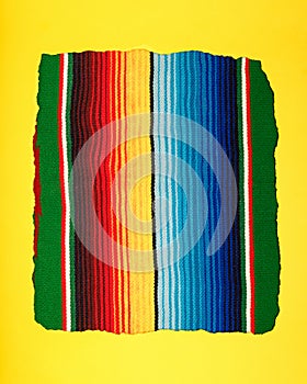 Yellow scrap paper on colorful serape. Empty template for text