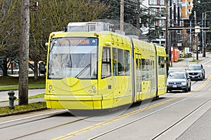 Yellow Seattle streetcar on East Yesler Way with pantograph down