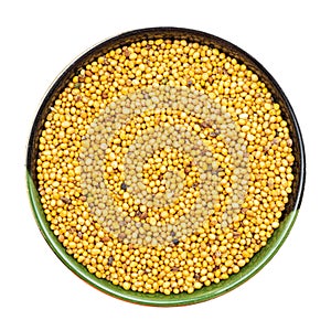 Yellow seeds of mustard in round bowl isolated