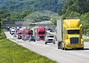 A yellow semi leads a packed line of traffic down an interstate in Tennessee