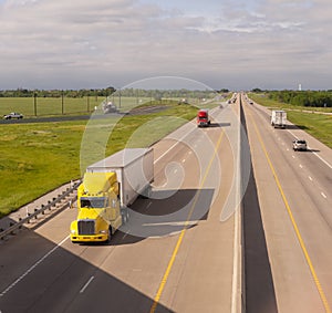 Yellow Semi Truck Trailer Rig Hauls Freight on Divided Highway