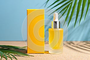 Yellow serum bottle and box with tropical leaves